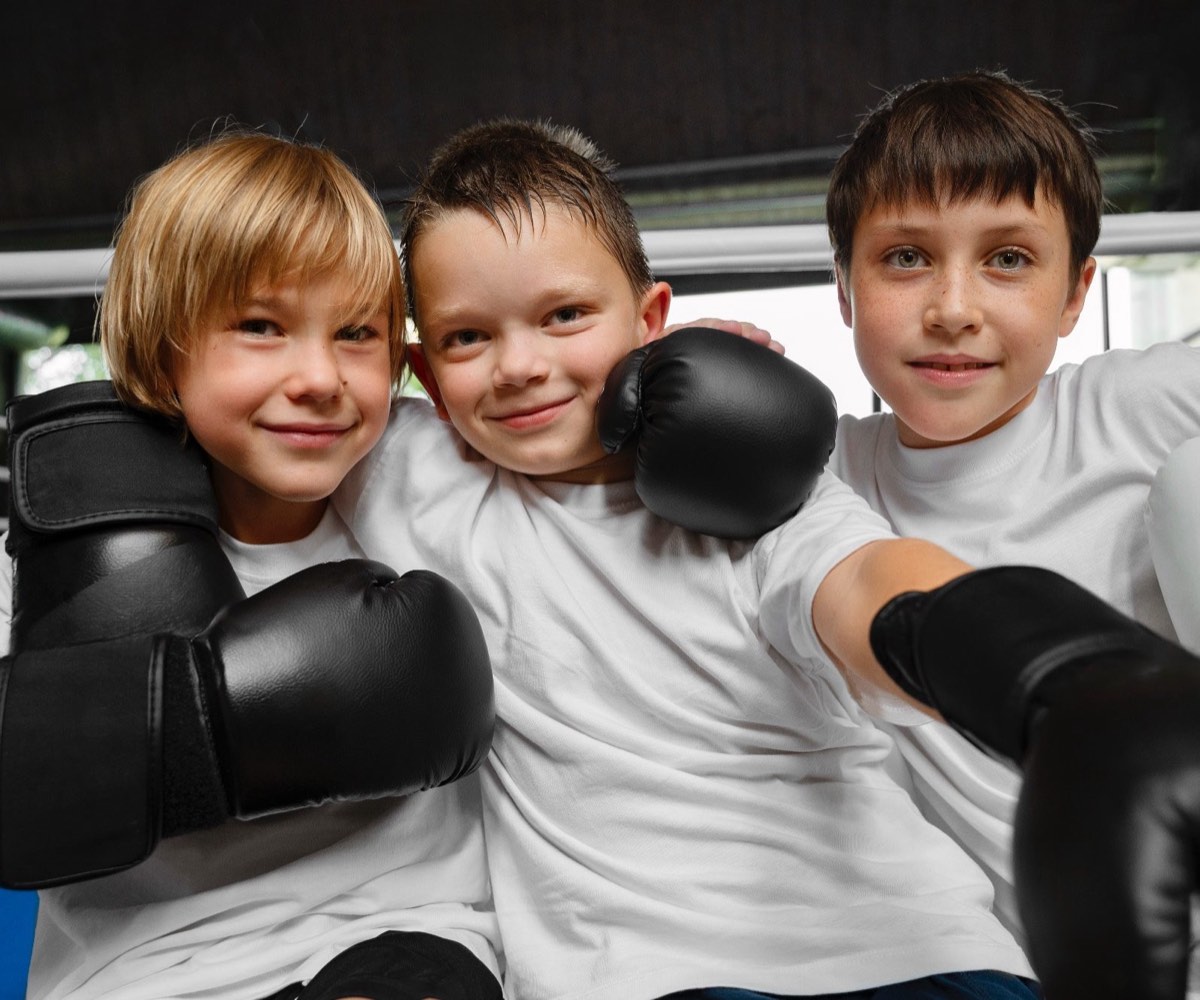 Drei Kinder mit Boxhandschuhen beim Kindertraining